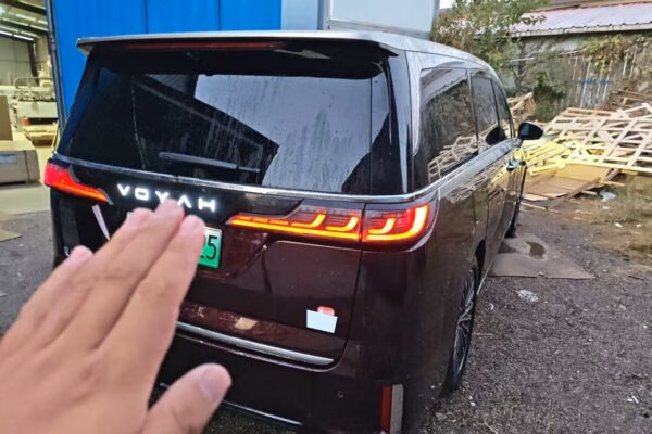 Rear view of a dark red VOYAH Dreamer MPV with the illuminated VOYAH light bar across the tailgate